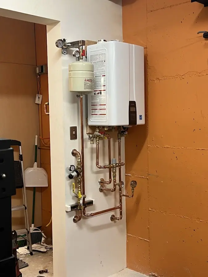 Plumbing technician inspecting water heater connections in Wright